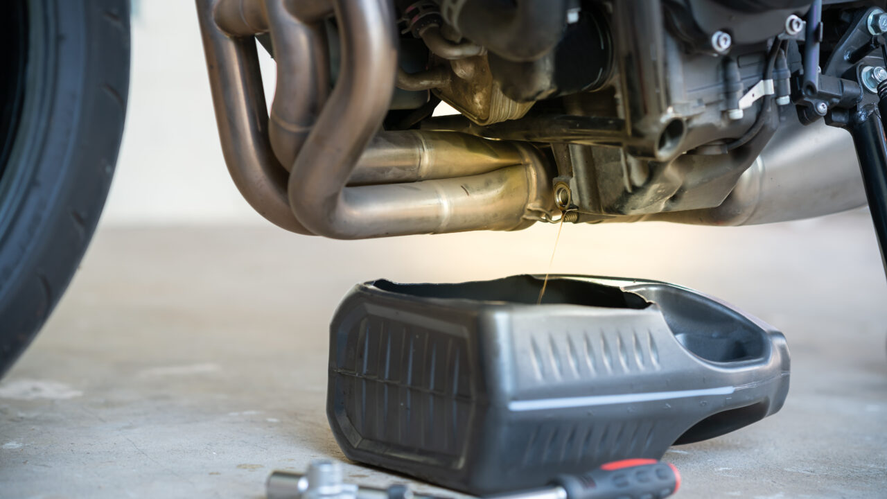 Vidange de l'huile moteur d'une moto de motocross par le bouchon de vidange