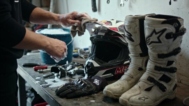 Nettoyage d'un casque et de gants de motocross avec un chiffon et de l'eau savonneuse