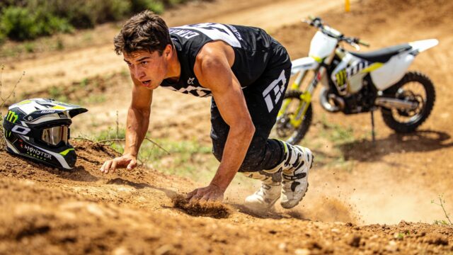 Pilote de motocross en pleine séance de préparation physique, entraînement cardio et gainage à côté de sa moto