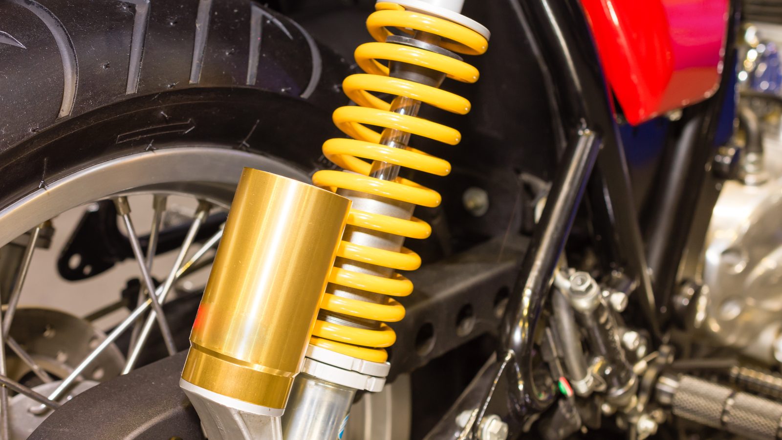 Amortisseur arrière de moto vu de près, ressort et corps de suspension visibles