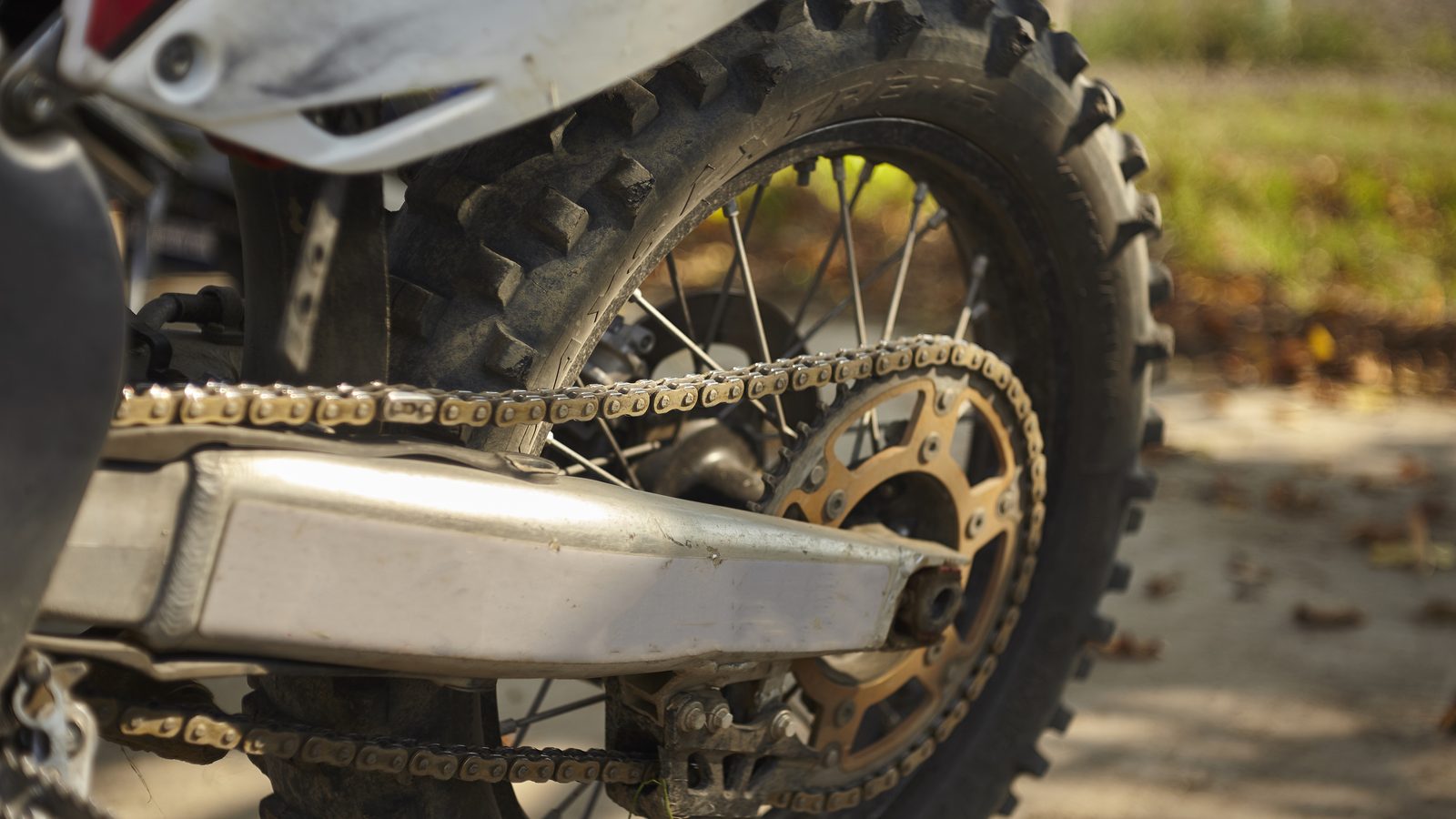 Bras oscillant et roue arrière d'une moto de motocross, chaîne tendue le long du bras