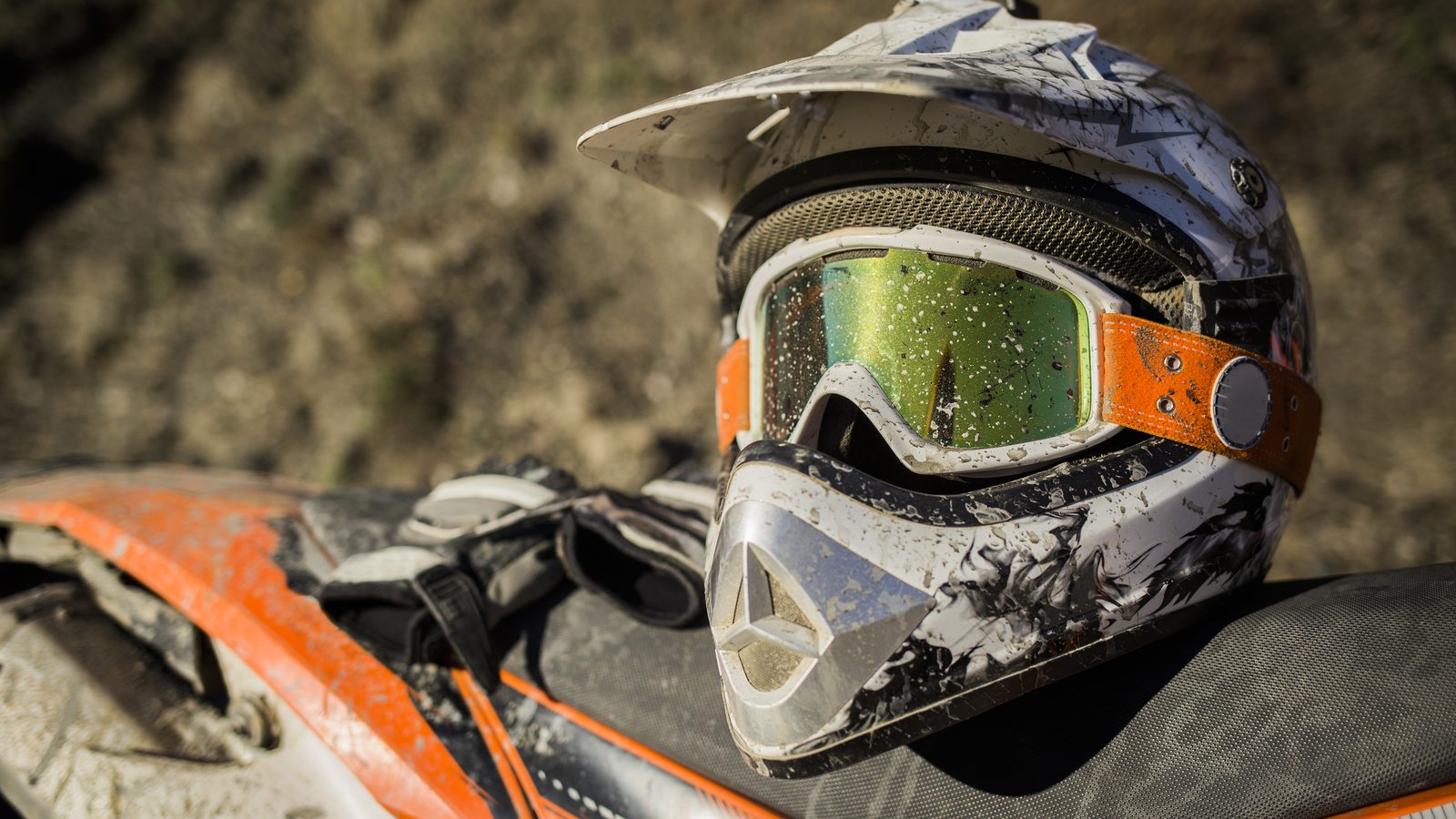 Casque de motocross couvert de terre, masque encore fixé sur la coque