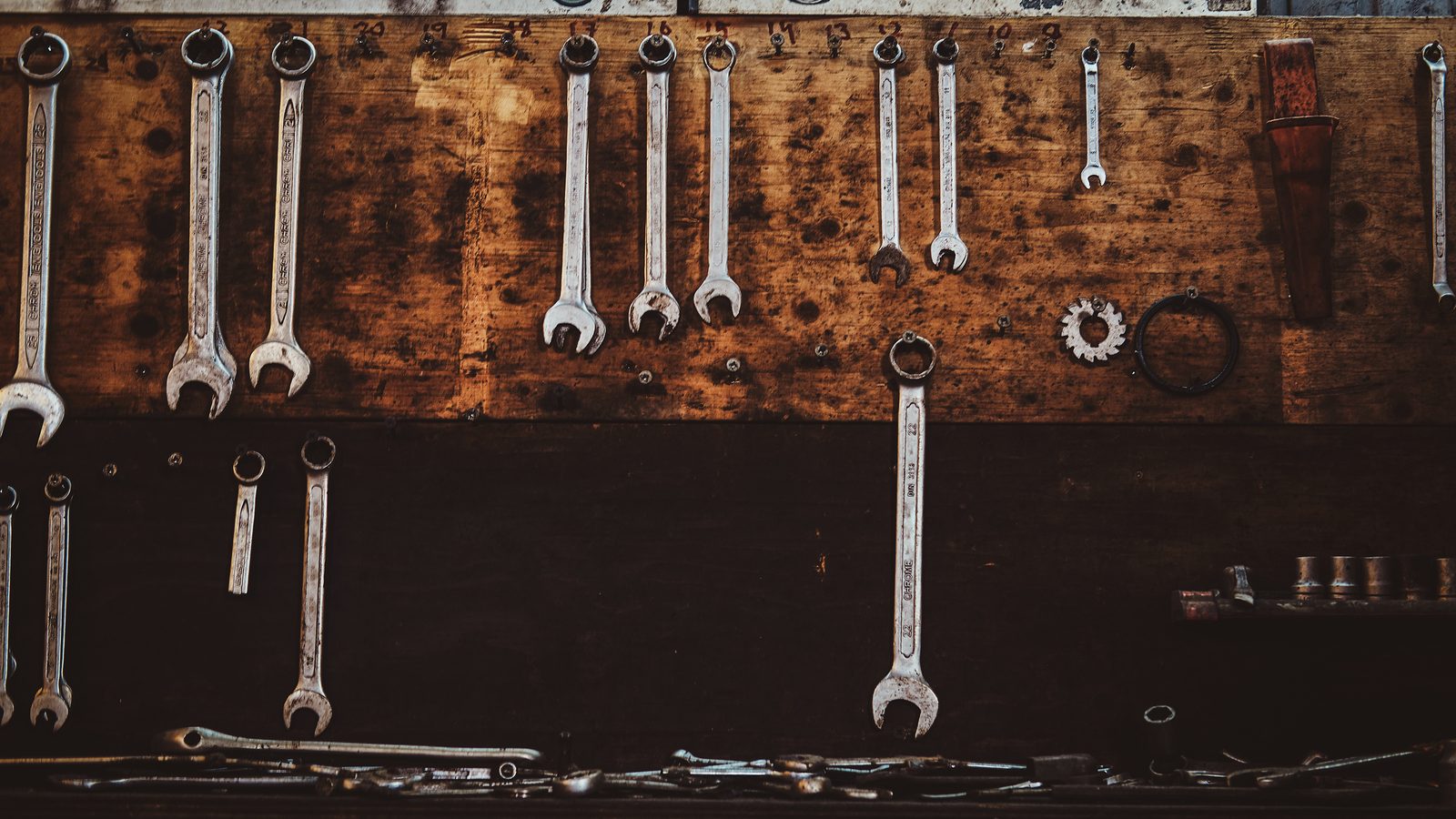 Clés et outils à main accrochés au mur d'un atelier, rangés par taille