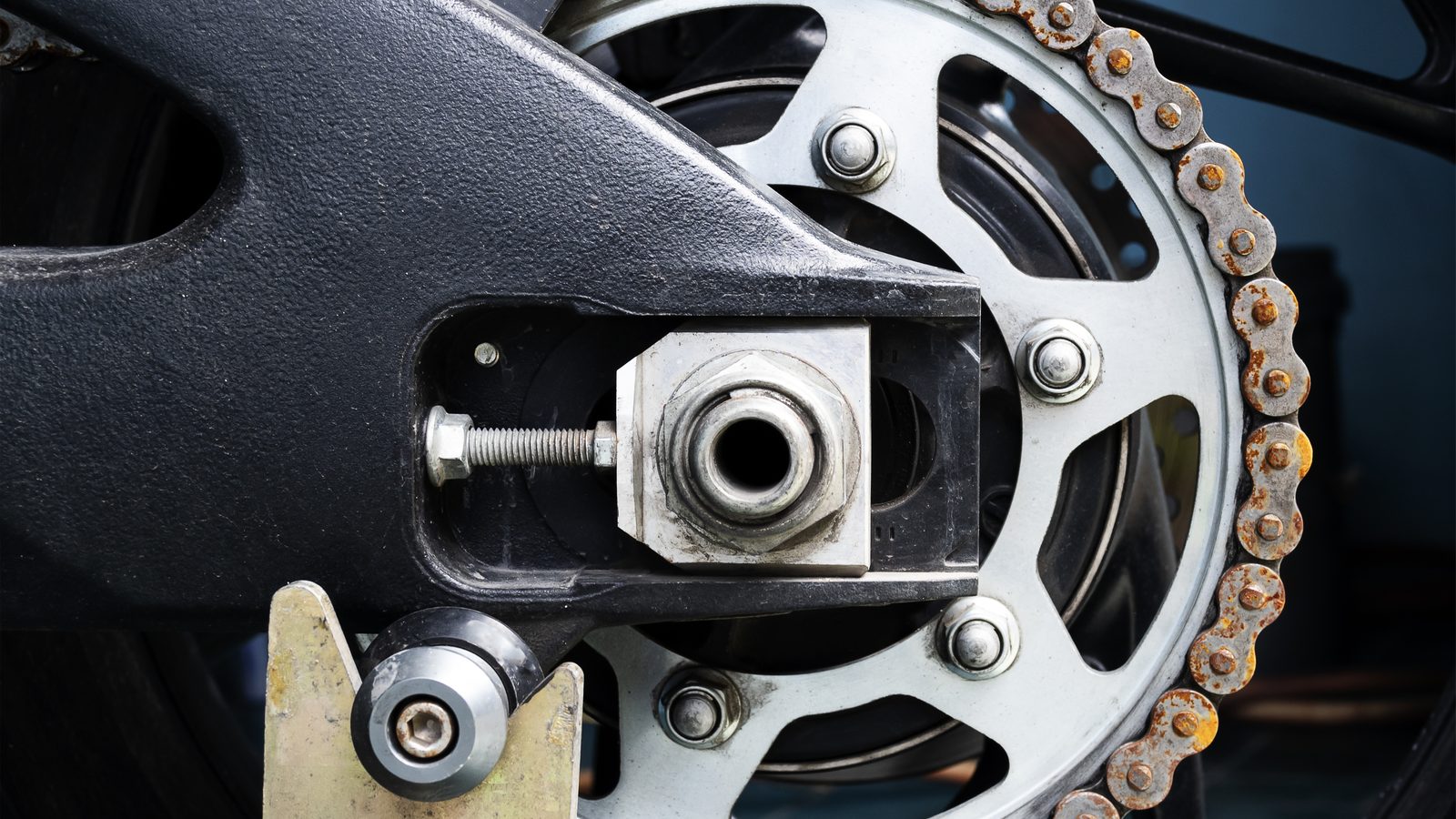 Couronne de moto aux dents usées avec une chaîne rouillée, vue rapprochée