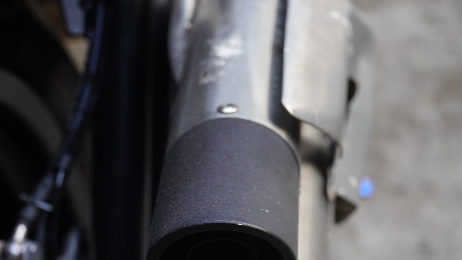 Gros plan sur la sortie du silencieux d'une moto, corps métallique et rivets visibles