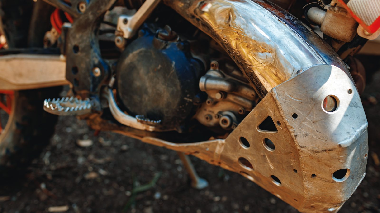 Gros plan sur le bloc moteur d'une moto de motocross, carters et sélecteur visibles