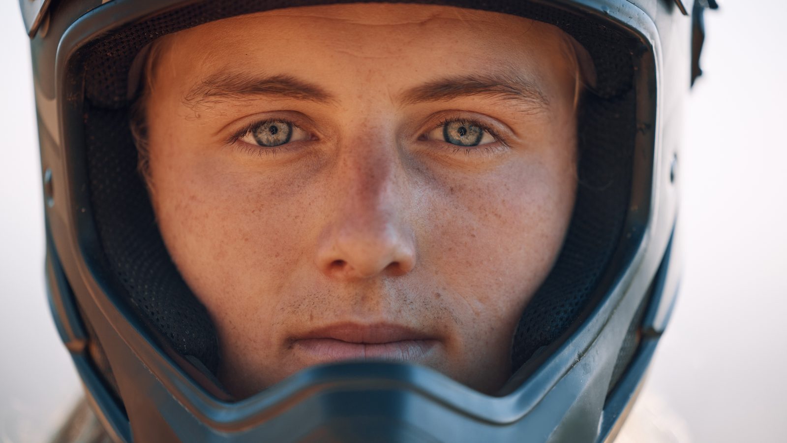 Portrait rapproché d'un pilote portant son casque de motocross en extérieur
