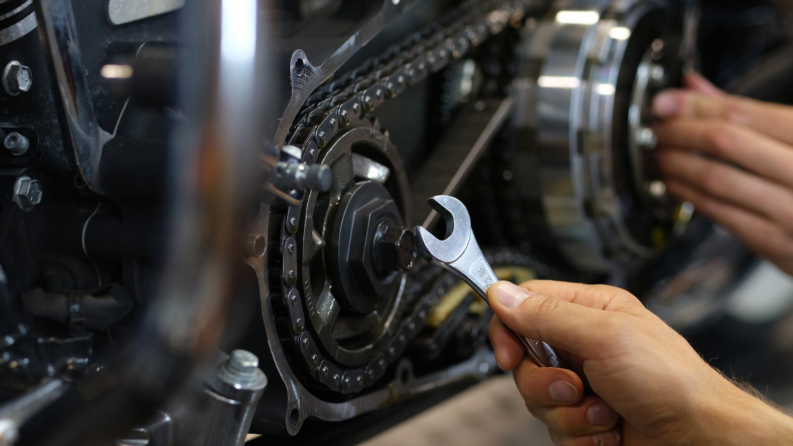 Techniciens contrôlant le système d'embrayage sur un moteur de moto partiellement démonté