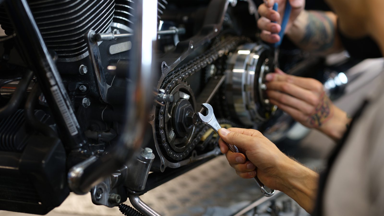 Techniciens travaillant sur le système d'embrayage d'un moteur de moto ouvert