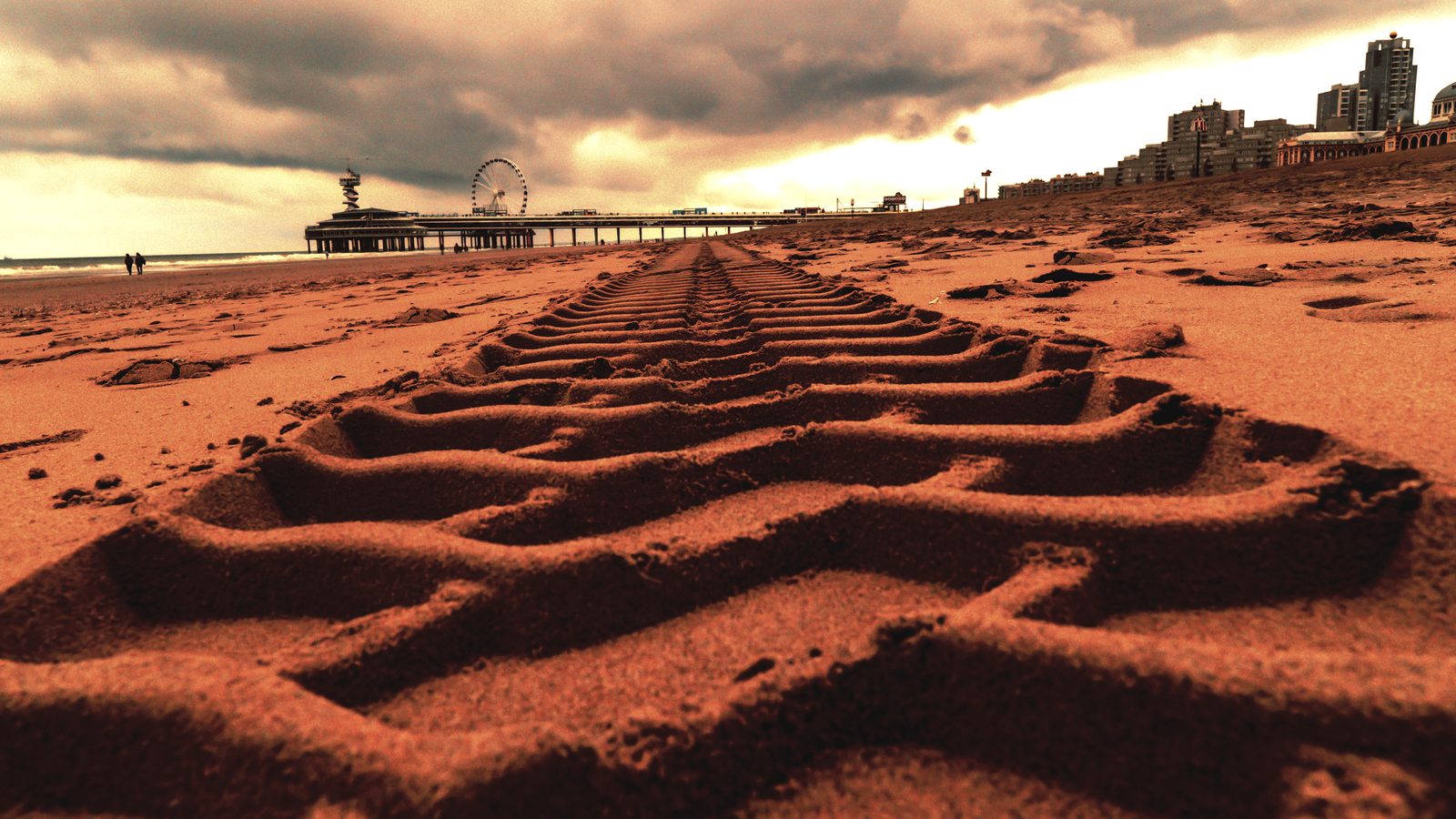 Traces de pneu creusées dans le sable meuble d'une piste, relief marqué par les passages