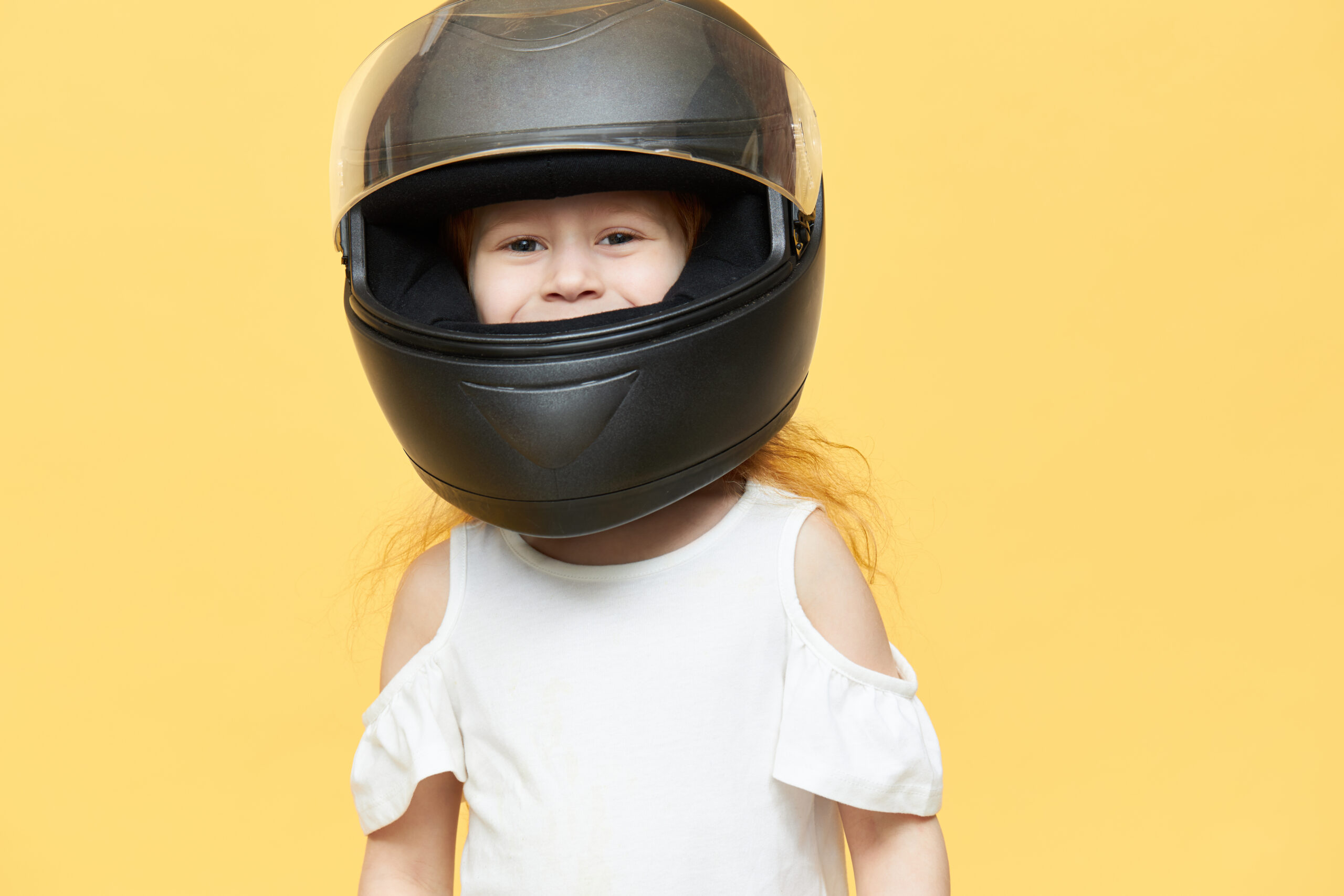 Portrait d'un enfant équipé d'un casque de motocross complet, prêt à rouler en toute sécurité.