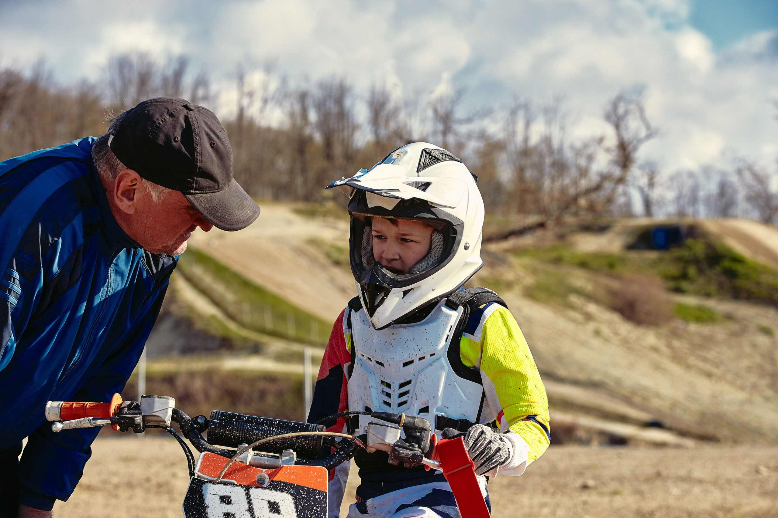 Jeune pilote en équipement complet de motocross roulant sur sa moto lors d'une compétition junior.