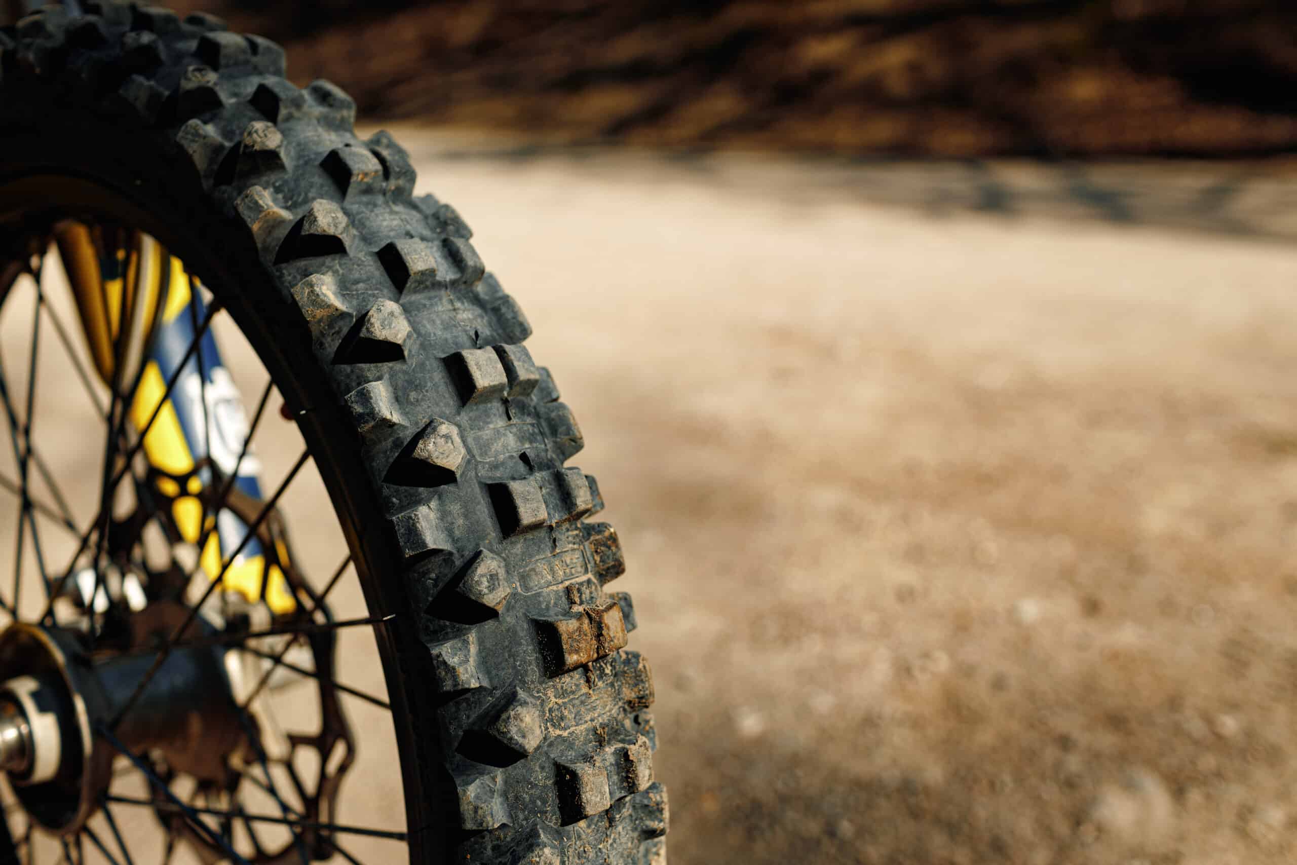 Gros plan sur la bande de roulement crantée d'un pneu arrière de moto de motocross